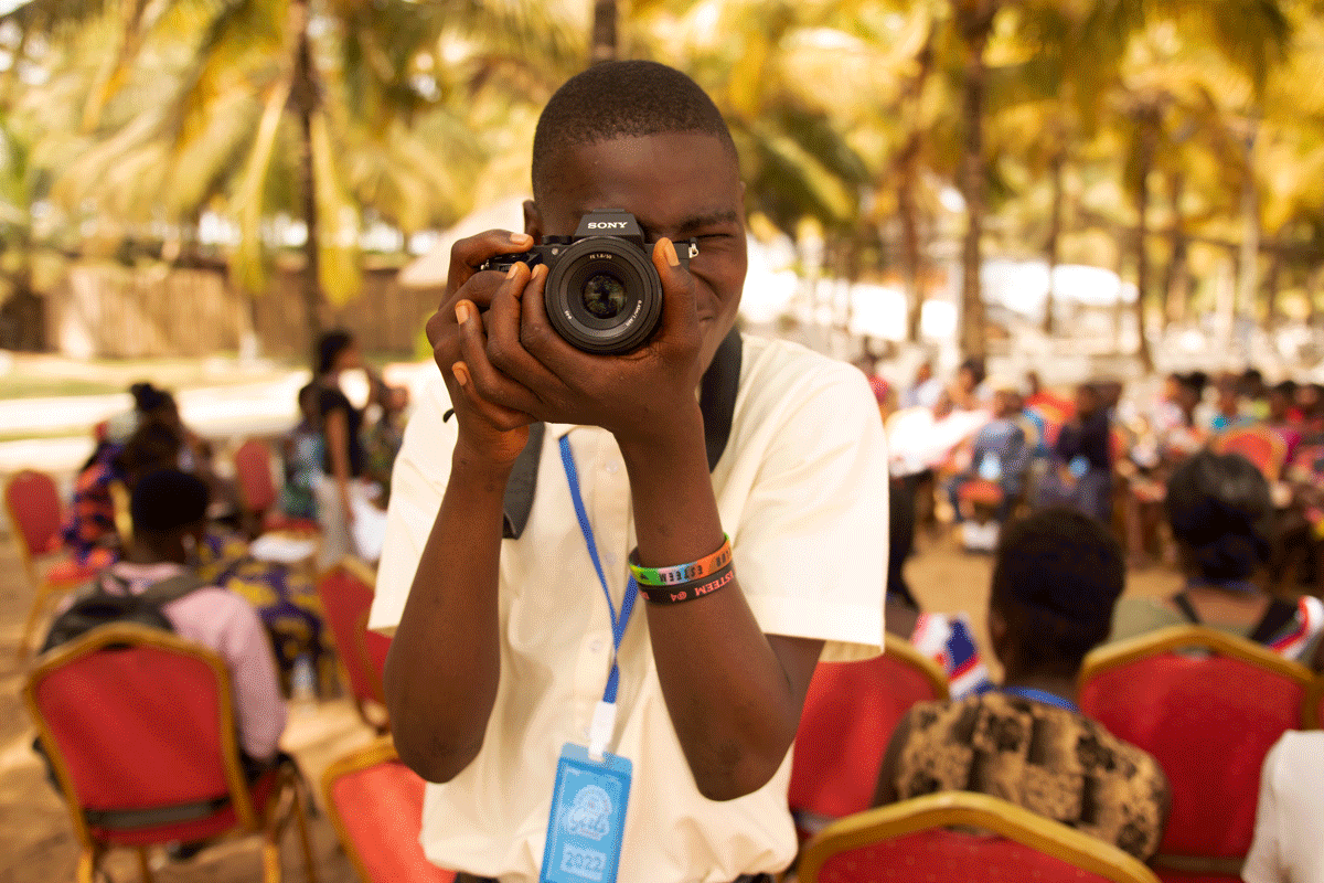 A boy takes pictures at the 2022 West Africa Adolescent Girls Summit